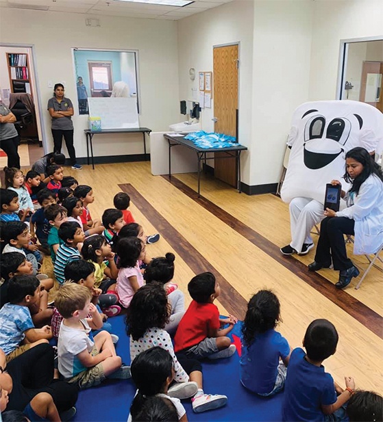 Dentist and tooth mascot teaching kids