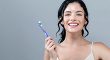 Woman smiling while holding toothbrush