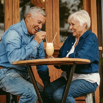 Senior couple with dentures in Frisco sharing a milkshake