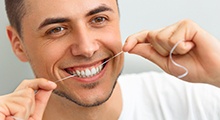 man flossing his dental implants Frisco