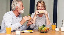 Older couple eating lunch with dental implants in Frisco