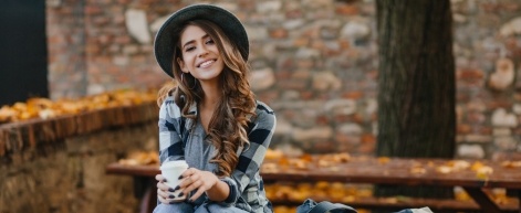 Smiling woman with coffee cup outdoors