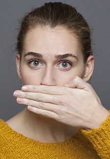 nervous woman covering her mouth