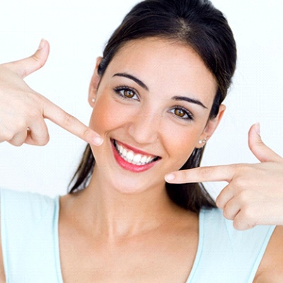 woman pointing to her white smile 