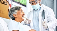Dentist showing patient their smile in handheld mirror
