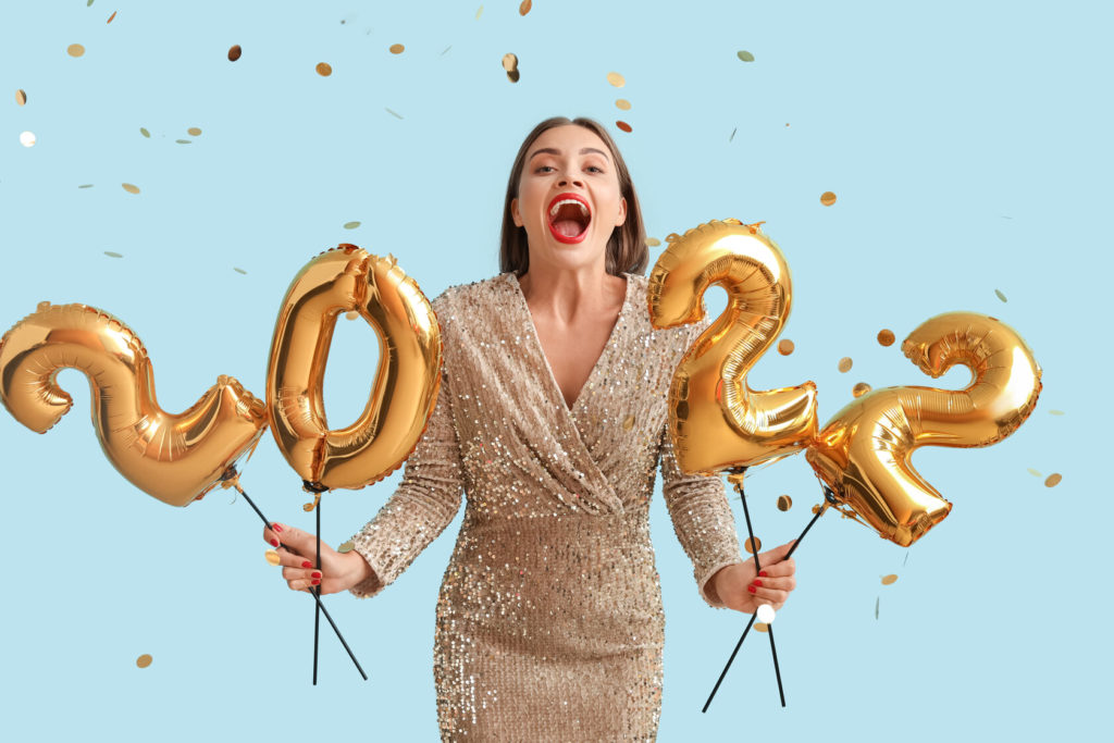 person smiling and holding 2022 New Year’s balloons