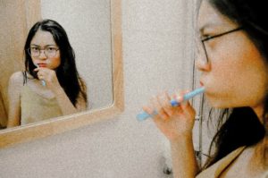 Woman brushing her teeth in the bathroom.