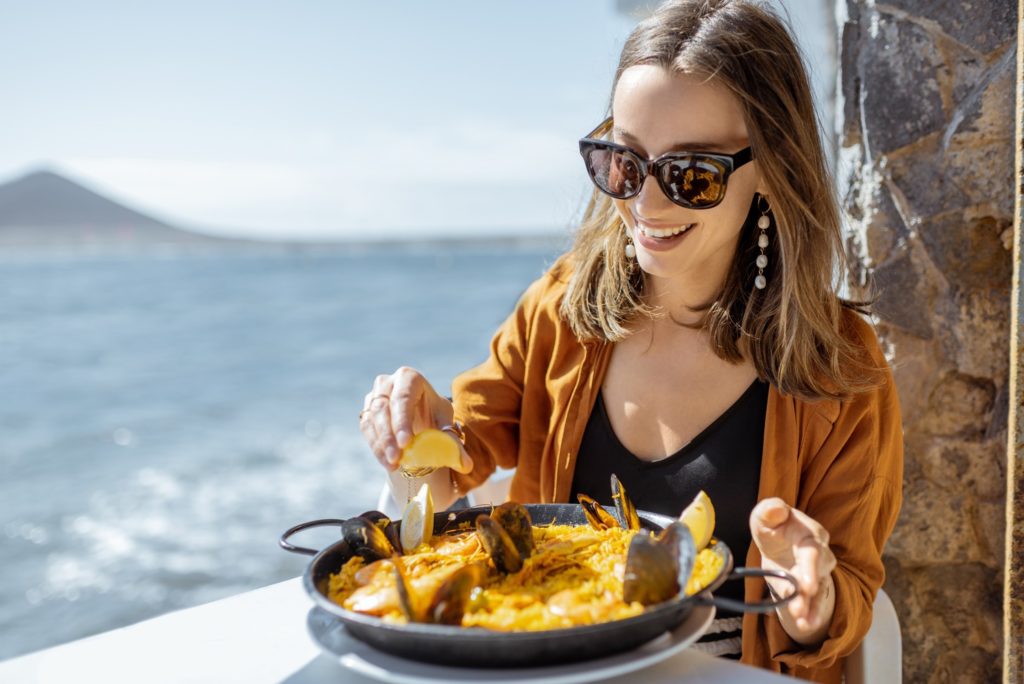 Woman smiling while eating lunch at restaurant on the water